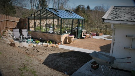 Drivhuset og den uferdige hagen fra en annen vinkel.
